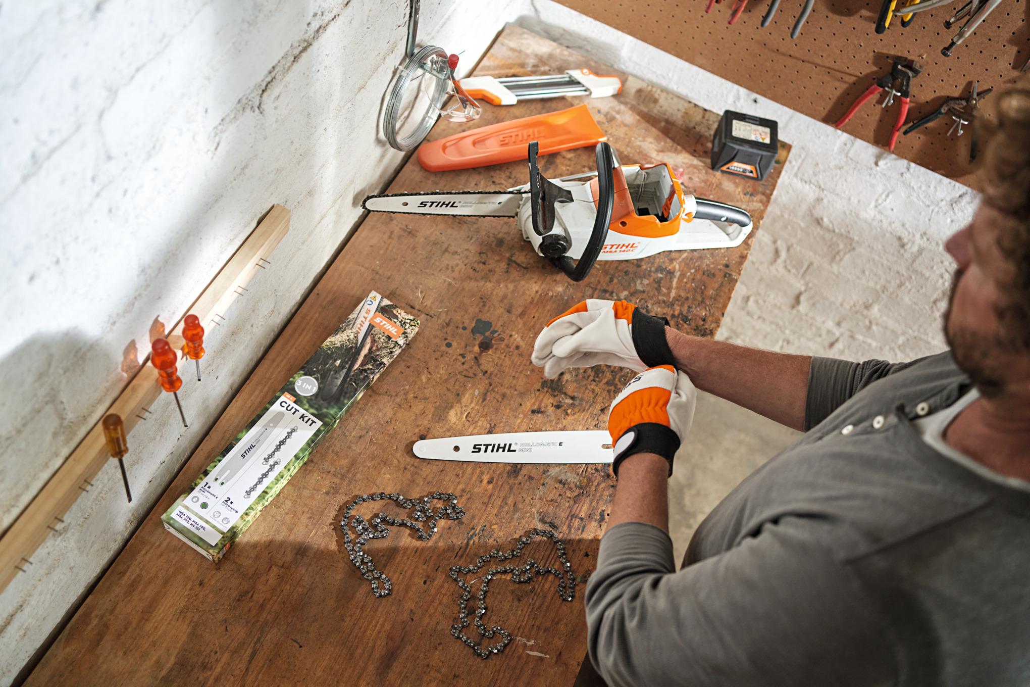 Man preparing chainsaw for use with the help of a service kit.